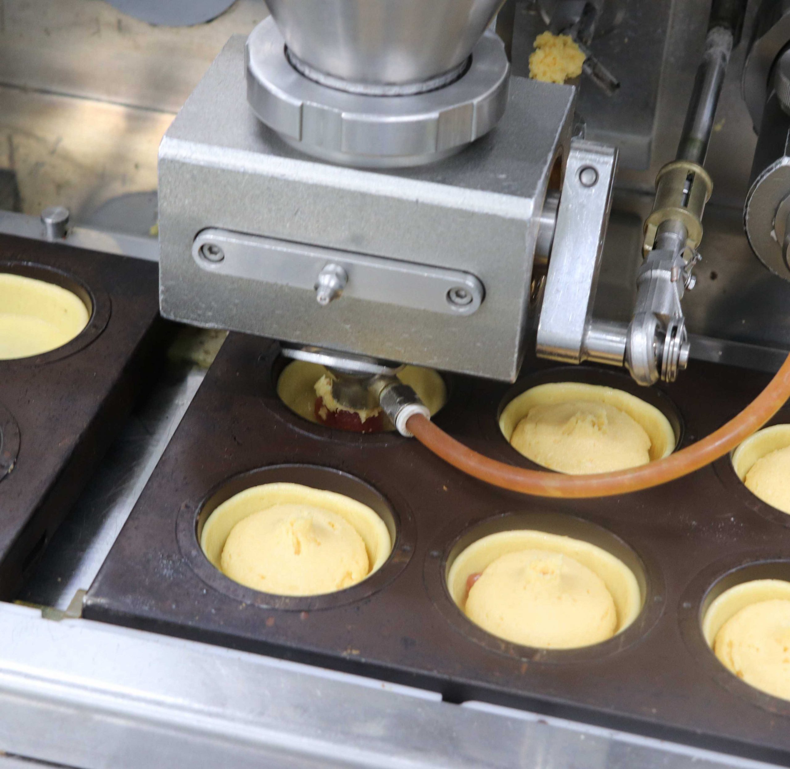 At the 3rd head, the filling batter and kanpyo jam is deposited at the same time.
