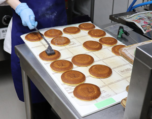 Logo is branded on the freshly baked pancakes, and then red bean paste and mochi is sandwiched inside.