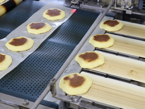 After baking, the paper is automatically peeled off, red bean paste is deposited, and then sandwiched with another pancake.