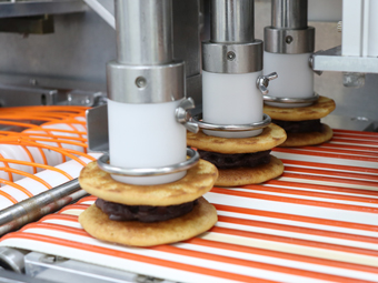 Red bean paste is deposited and sandwiched.