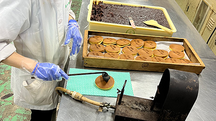 オリジナルの焼きごてで焼印を押す様子